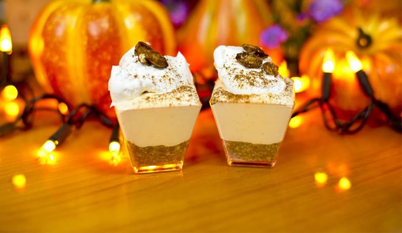 Mini no-bake pumpkin cheesecakes in front of mini pumpkins