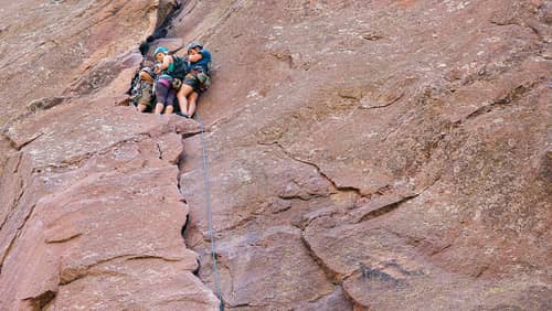 Rock climbers scaling the red rock formations at Eldorado Canyon State Park